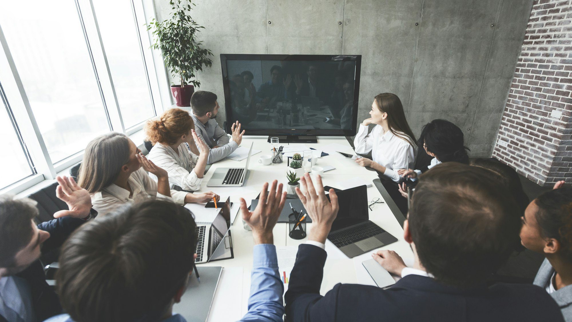 Businesspeople watching online presentation on tv screen