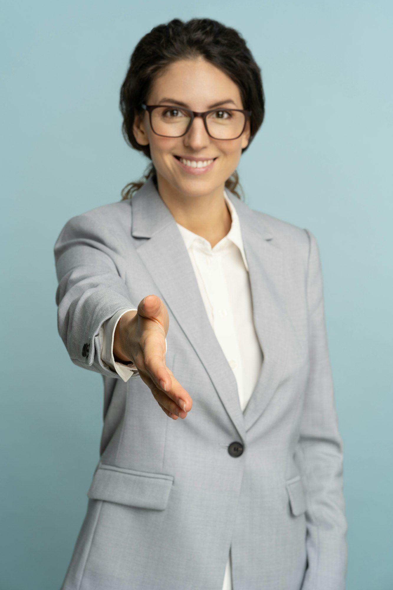 friendly hospitable cheerful business woman or office worker wear blazer giving hand to handshake