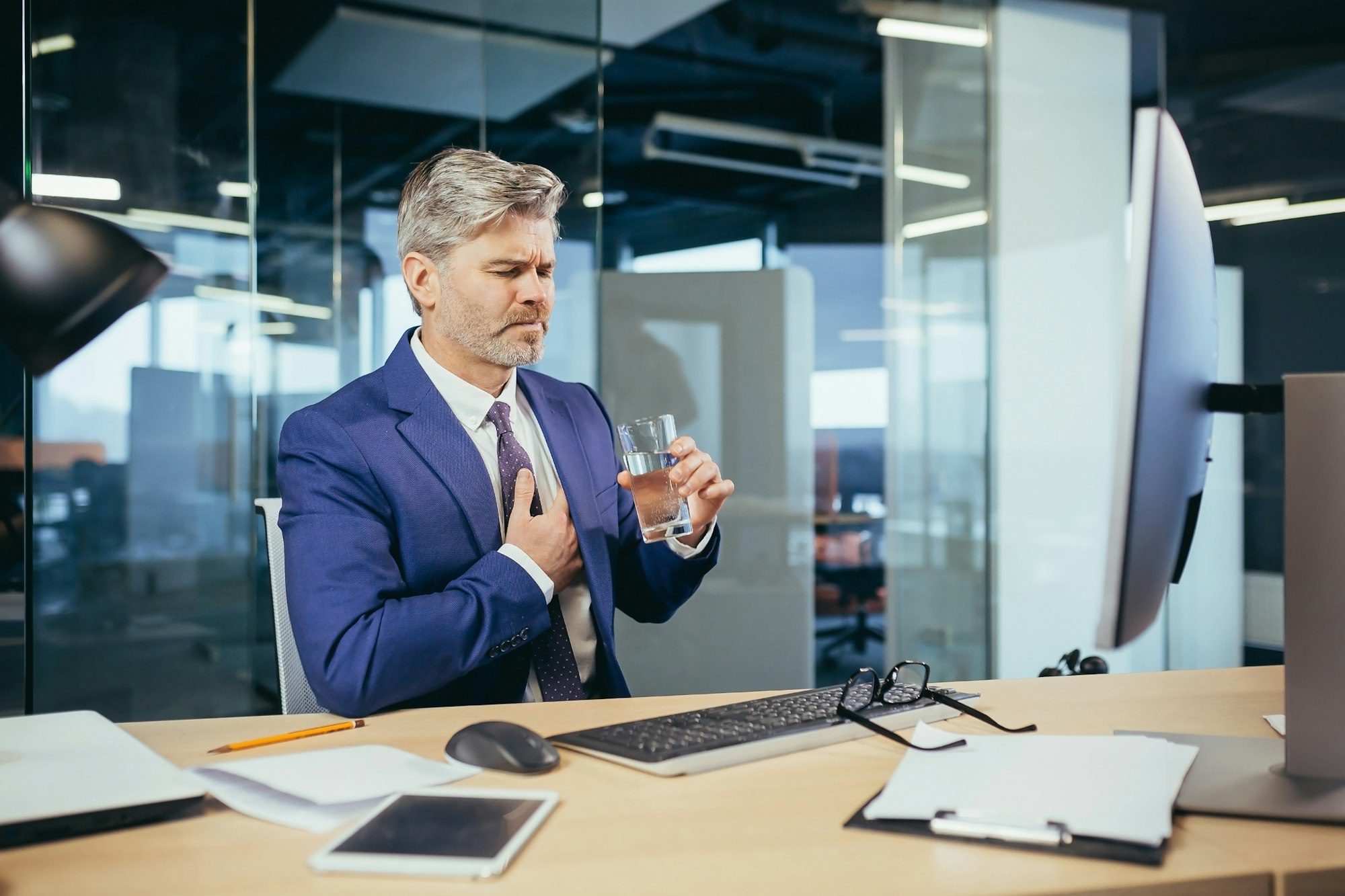 gray haired businessman has a severe chest pain an experienced worker working