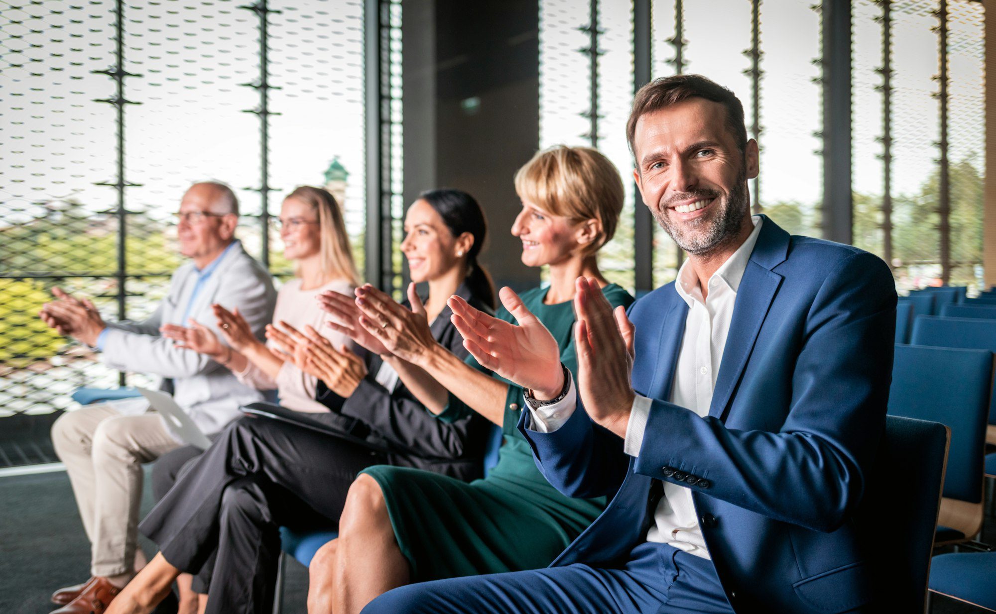 público feliz aplaudindo palestrante em conferência de negócios