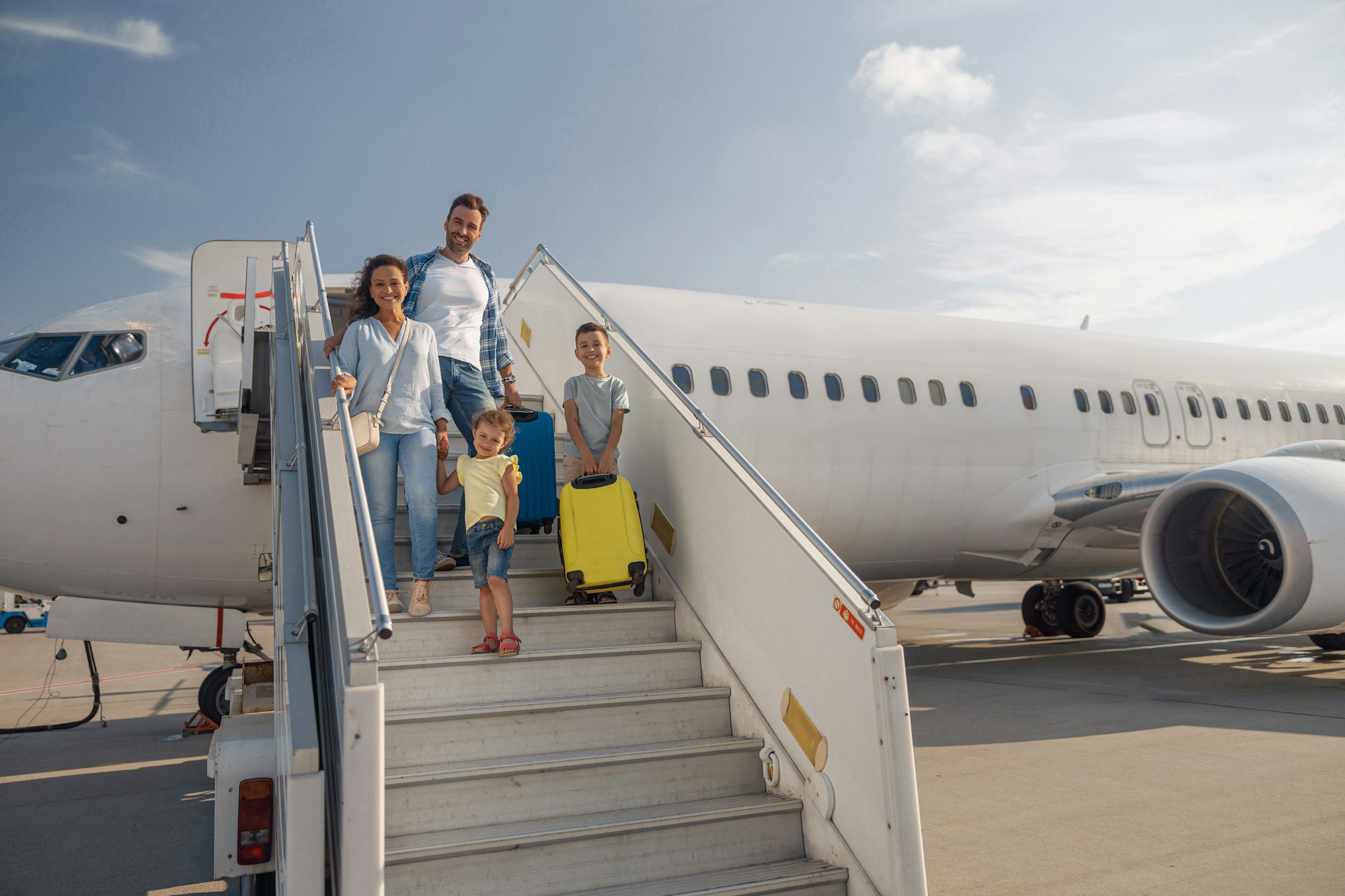 família feliz de quatro pessoas saindo do avião em um dia