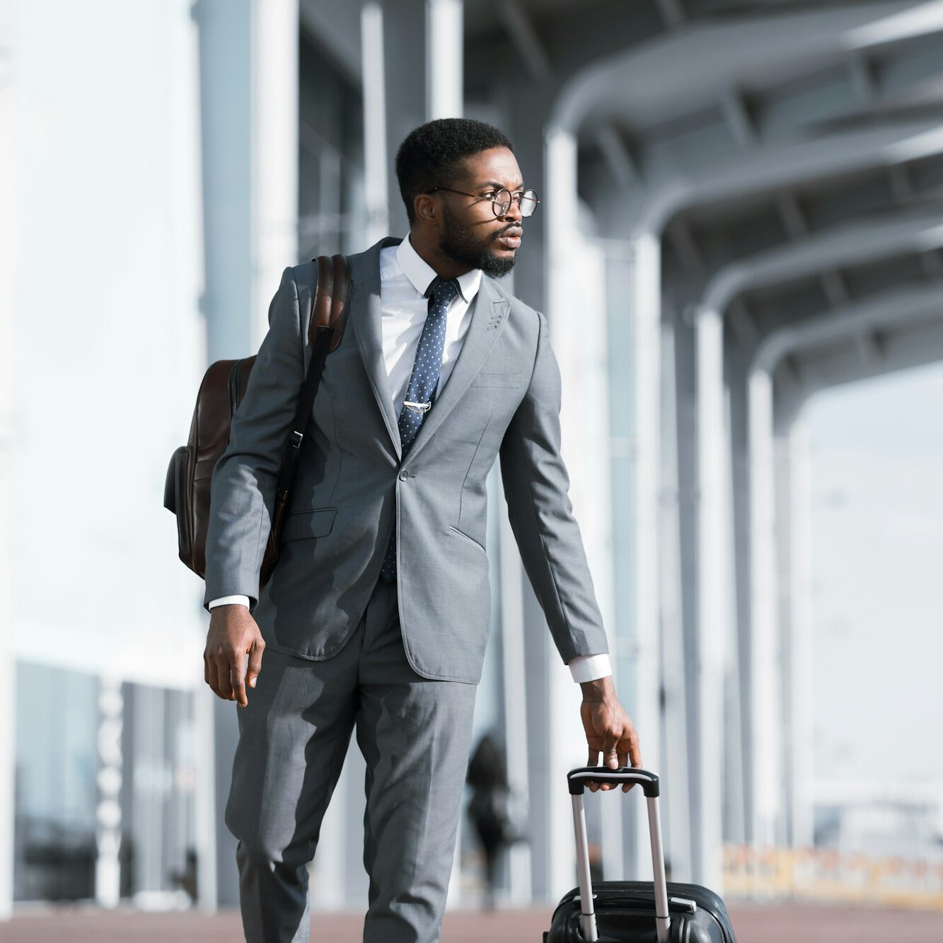 Homem de negócios africano sério em viagem de negócios caminhando perto do aeroporto